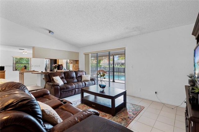 988 NW 110th Ave, Coral Springs, FL 33071 - living area featuring a textured ceiling, light tile patterned floors, and vaulted ceiling