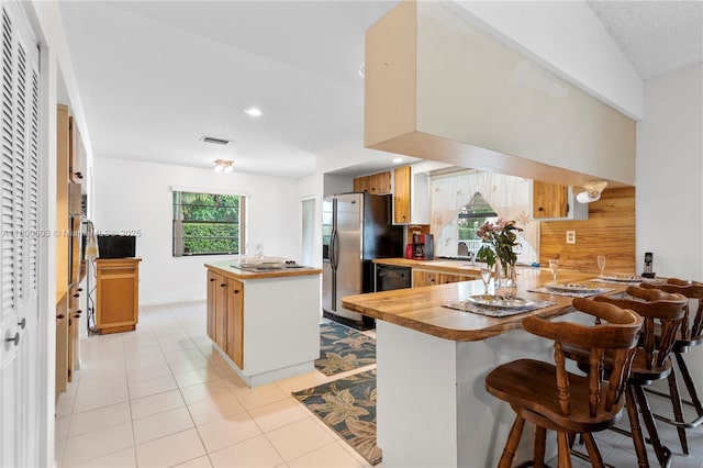 988 NW 110th Ave, Coral Springs, FL 33071 - kitchen featuring butcher block countertops, fridge with ice dispenser, a center island, a peninsula, and tasteful backsplash