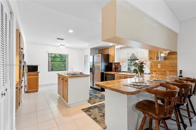 988 NW 110th Ave, Coral Springs, FL 33071 - kitchen featuring butcher block countertops, stainless steel appliances, a center island, a peninsula, and backsplash