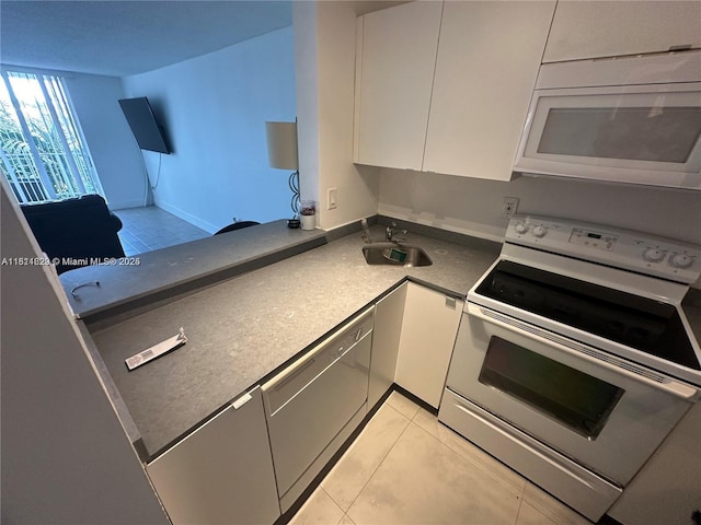 486 NW 165th St Rd Unit B-303, Miami, FL 33169 - kitchen with white appliances, a sink, white cabinetry, and dark countertops