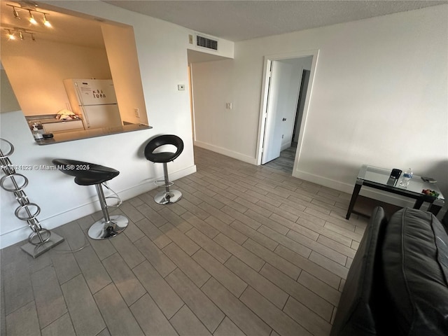486 NW 165th St Rd Unit B-303, Miami, FL 33169 - kitchen featuring freestanding refrigerator, baseboards, and a kitchen bar