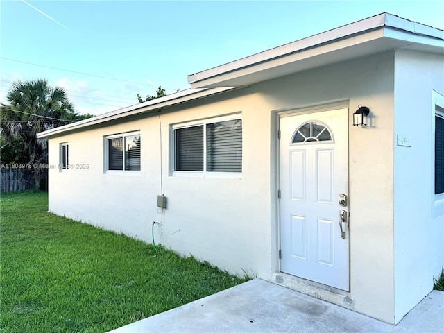 4341 NW 59th St, North Lauderdale, FL 33319 - view of exterior entry featuring stucco siding and a yard
