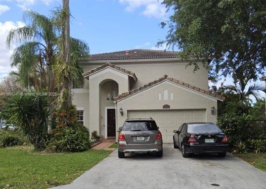 11920 SW 20th St, Miramar, FL 33025 - mediterranean / spanish home with concrete driveway, stucco siding, a tiled roof, and an attached garage