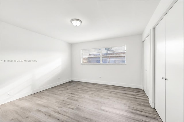 1461 NE 150th St Unit 103, Miami, FL 33161 - unfurnished bedroom featuring light wood-type flooring, a closet, and baseboards