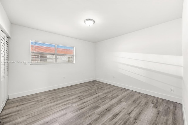 1461 NE 150th St Unit 103, Miami, FL 33161 - unfurnished bedroom featuring wood finished floors, baseboards, and a closet