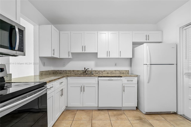 2500 SW 81st Ave Unit 402, Davie, FL 33324 - kitchen featuring appliances with stainless steel finishes, white cabinets, a sink, light stone counters, and light tile patterned floors