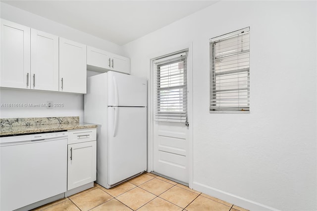 2500 SW 81st Ave Unit 402, Davie, FL 33324 - kitchen with white appliances, white cabinets, light tile patterned flooring, light stone counters, and baseboards