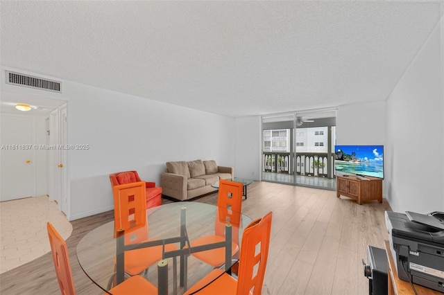 500 NE 12th Ave Unit 407, Hallandale Beach, FL 33009 - dining room featuring a textured ceiling, light wood-type flooring, and a ceiling fan