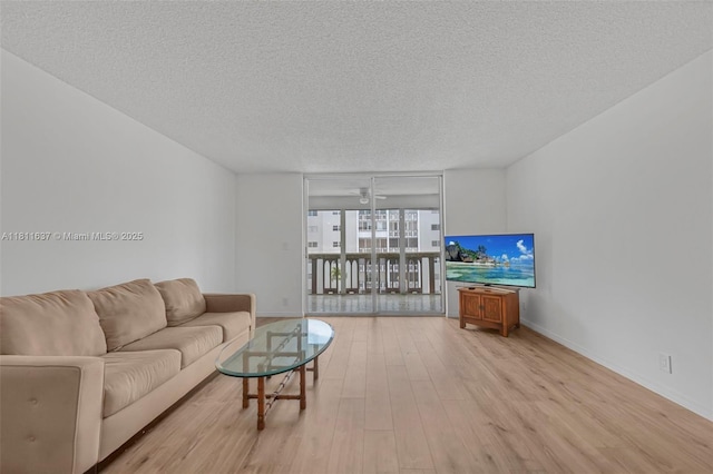 500 NE 12th Ave Unit 407, Hallandale Beach, FL 33009 - living area featuring floor to ceiling windows, a textured ceiling, wood finished floors, and baseboards
