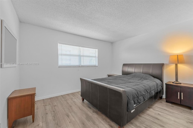 500 NE 12th Ave Unit 407, Hallandale Beach, FL 33009 - bedroom featuring a textured ceiling, light wood-type flooring, and baseboards