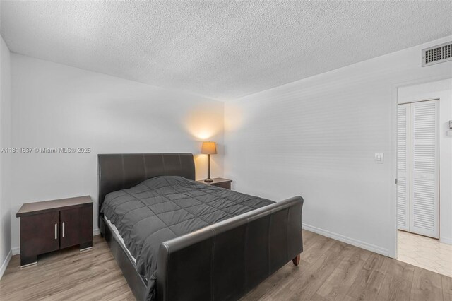 500 NE 12th Ave Unit 407, Hallandale Beach, FL 33009 - bedroom featuring wood finished floors, a textured ceiling, and baseboards