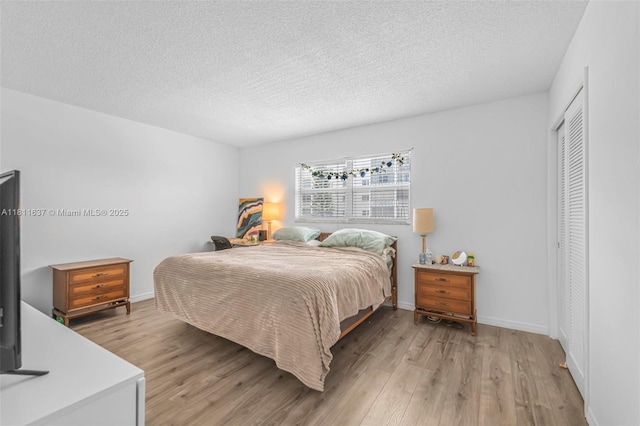 500 NE 12th Ave Unit 407, Hallandale Beach, FL 33009 - bedroom featuring light wood-style floors, a textured ceiling, baseboards, and a closet