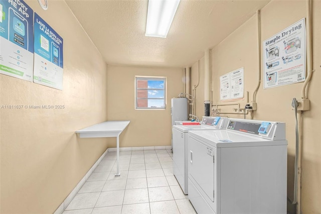 500 NE 12th Ave Unit 407, Hallandale Beach, FL 33009 - communal laundry room featuring washer and clothes dryer, a textured ceiling, light tile patterned floors, and baseboards