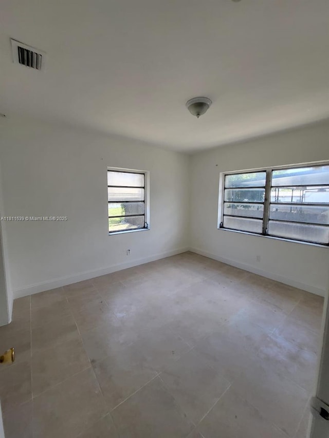 640-642 NW 77th St, Miami, FL 33150 - empty room featuring plenty of natural light, baseboards, and light tile patterned flooring