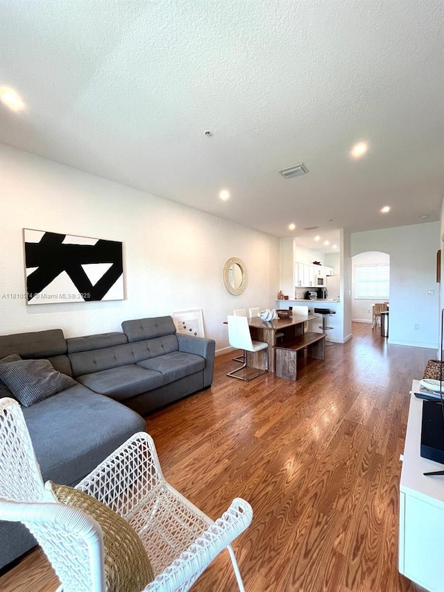 5670 NW 116th Ave Unit 212, Doral, FL 33178 - living area with wood finished floors, arched walkways, a textured ceiling, and recessed lighting