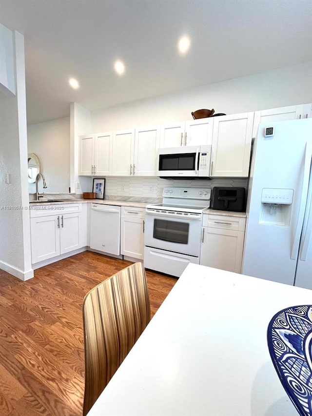 5670 NW 116th Ave Unit 212, Doral, FL 33178 - kitchen with white appliances, white cabinets, wood finished floors, light countertops, and recessed lighting