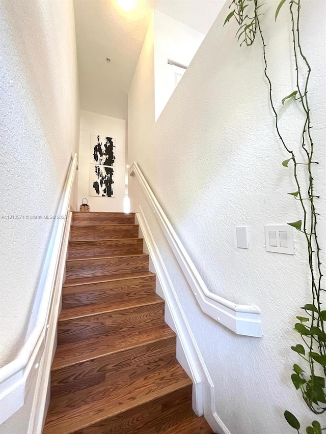 5670 NW 116th Ave Unit 212, Doral, FL 33178 - stairs featuring wood finished floors and a textured wall