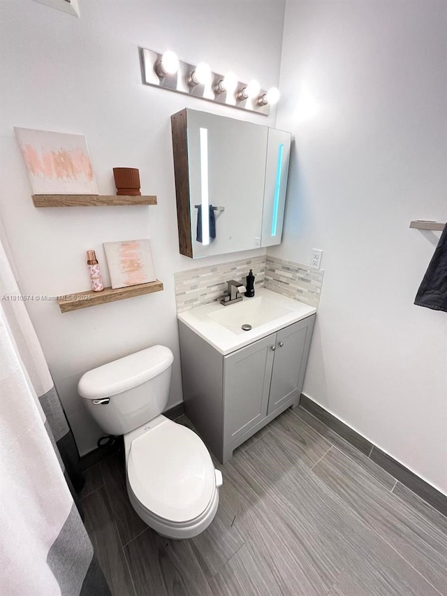 5670 NW 116th Ave Unit 212, Doral, FL 33178 - bathroom with toilet, vanity, tasteful backsplash, and baseboards