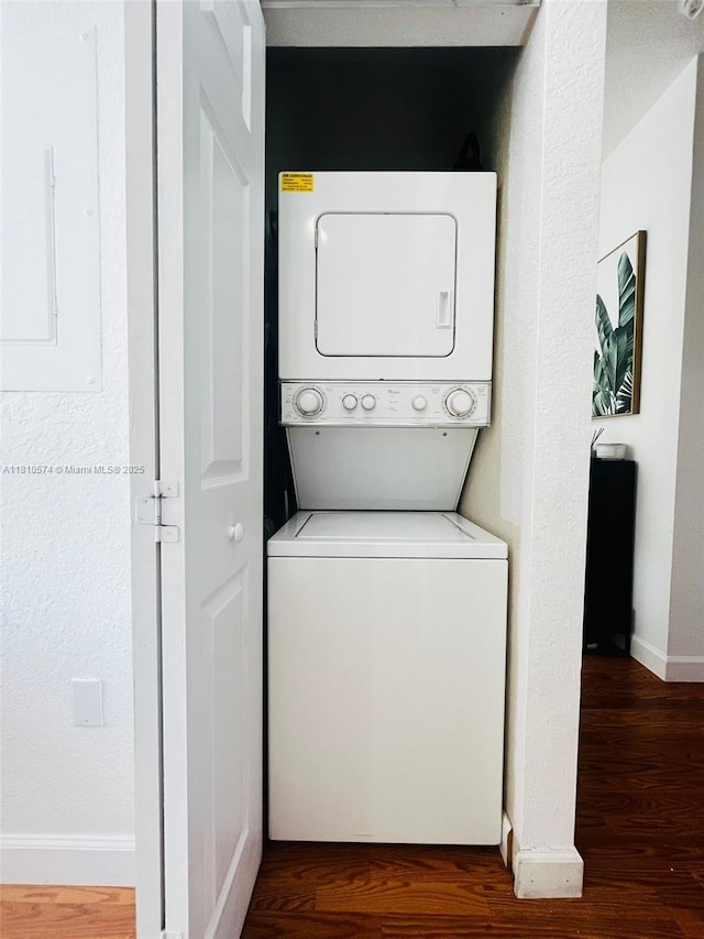 5670 NW 116th Ave Unit 212, Doral, FL 33178 - laundry room featuring stacked washer / drying machine, wood finished floors, electric panel, and baseboards