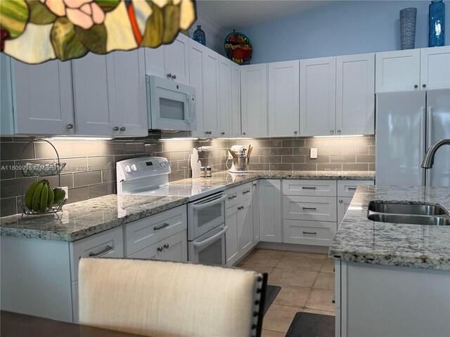 16306 SW 11th St, Pembroke Pines, FL 33027 - kitchen with white appliances, a sink, decorative backsplash, white cabinets, and light tile patterned floors