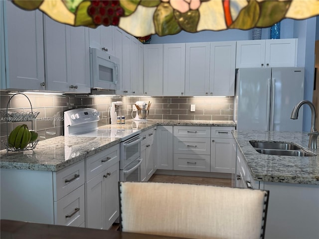 16306 SW 11th St, Pembroke Pines, FL 33027 - kitchen with white appliances, a sink, backsplash, and white cabinets