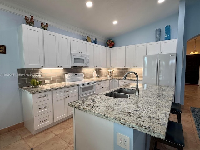 16306 SW 11th St, Pembroke Pines, FL 33027 - kitchen with white appliances, a sink, a kitchen breakfast bar, white cabinets, and recessed lighting