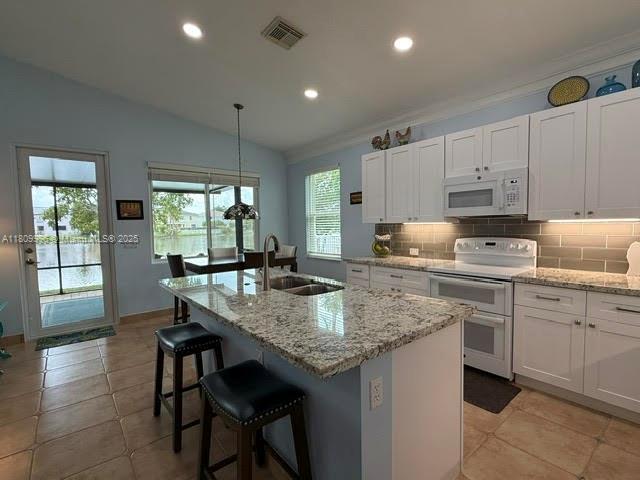 16306 SW 11th St, Pembroke Pines, FL 33027 - kitchen featuring white appliances, a sink, healthy amount of natural light, lofted ceiling, and tasteful backsplash