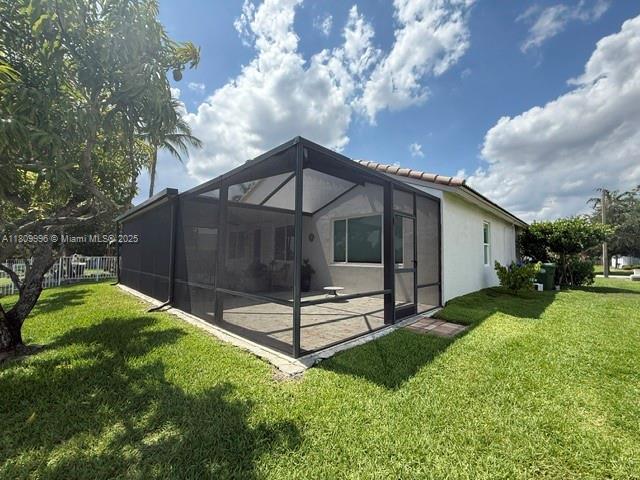 16306 SW 11th St, Pembroke Pines, FL 33027 - back of property with a patio area, stucco siding, and glass enclosure