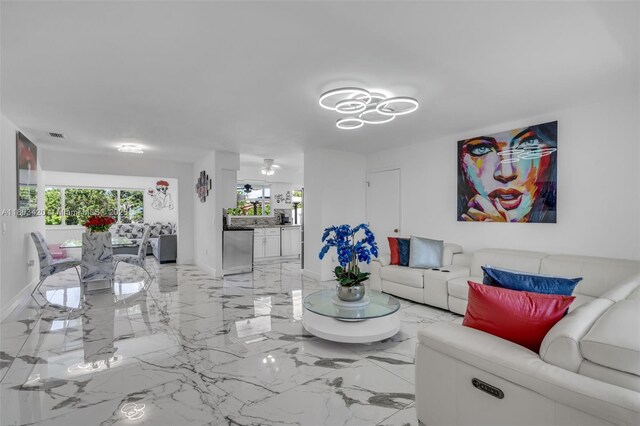 12351 NW 29th Mnr, Sunrise, FL 33323 - living area with light marble finish flooring, baseboards, and a chandelier