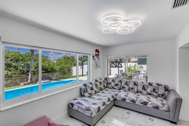 12351 NW 29th Mnr, Sunrise, FL 33323 - living area featuring marble look tile flooring, plenty of natural light, baseboards, and a chandelier