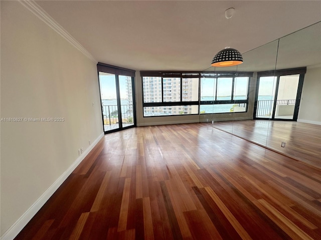 520 Brickell Key Dr Unit A811, Miami, FL 33131 - spare room featuring baseboards, wood finished floors, and ornamental molding