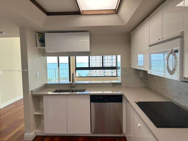 520 Brickell Key Dr Unit A811, Miami, FL 33131 - kitchen featuring stainless steel dishwasher, black electric stovetop, a sink, white microwave, and wood finished floors