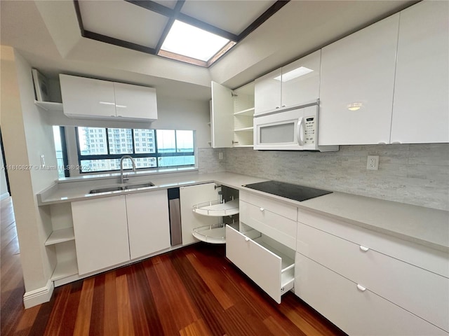 520 Brickell Key Dr Unit A811, Miami, FL 33131 - kitchen featuring open shelves, white microwave, black electric stovetop, a sink, and dark wood-style flooring