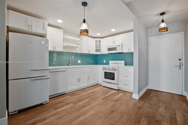 150 SE 25th Rd Unit 10K, Miami, FL 33129 - kitchen with white appliances, white cabinets, light wood-style floors, tasteful backsplash, and a sink