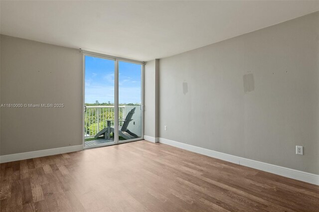 150 SE 25th Rd Unit 10K, Miami, FL 33129 - unfurnished room with a wall of windows, wood finished floors, and baseboards