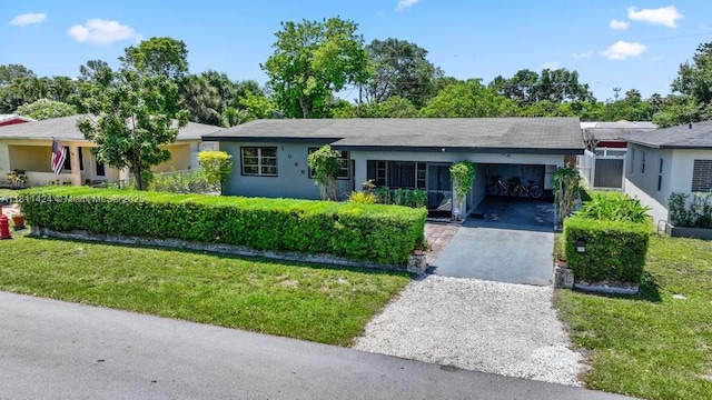 1090 SW 31st St, Fort Lauderdale, FL 33315 - ranch-style house featuring asphalt driveway, a front lawn, and a carport