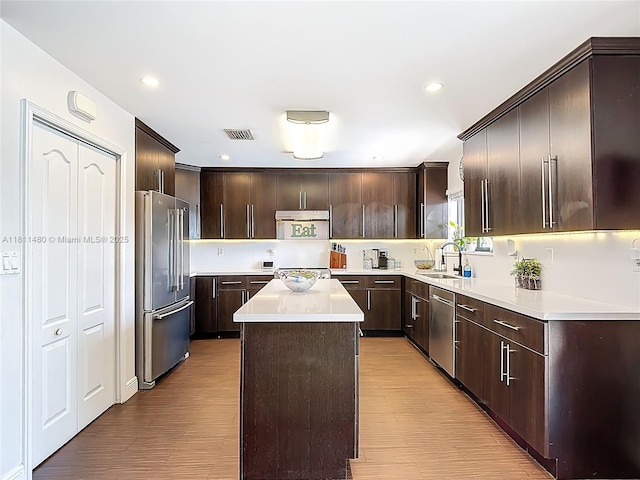 21241 SW 88th Pl, Cutler Bay, FL 33189 - kitchen with appliances with stainless steel finishes, a sink, light countertops, a kitchen island, and dark brown cabinets
