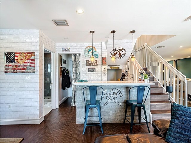 21241 SW 88th Pl, Cutler Bay, FL 33189 - kitchen featuring brick wall, dark wood finished floors, baseboards, a kitchen breakfast bar, and hanging light fixtures