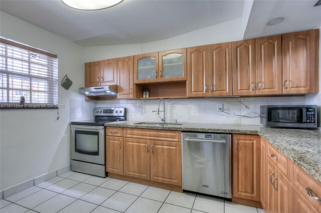 834 W 80th Pl, Hialeah, FL 33014 - kitchen featuring stainless steel appliances, under cabinet range hood, a sink, light stone countertops, and brown cabinets