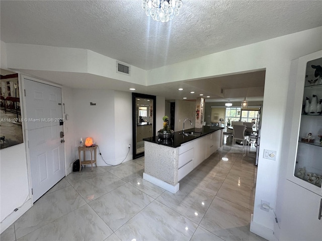 13700 SW 14th St Unit 412D, Pembroke Pines, FL 33027 - kitchen with a sink, a textured ceiling, modern cabinets, dark countertops, and white cabinets