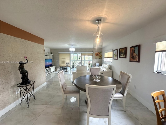 13700 SW 14th St Unit 412D, Pembroke Pines, FL 33027 - dining area with baseboards, healthy amount of natural light, a textured ceiling, and light marble finish flooring