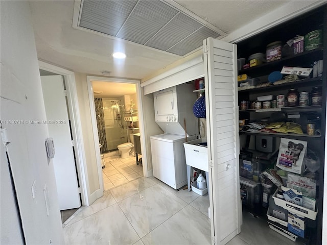 13700 SW 14th St Unit 412D, Pembroke Pines, FL 33027 - laundry room with estacked washer and dryer and light marble finish flooring