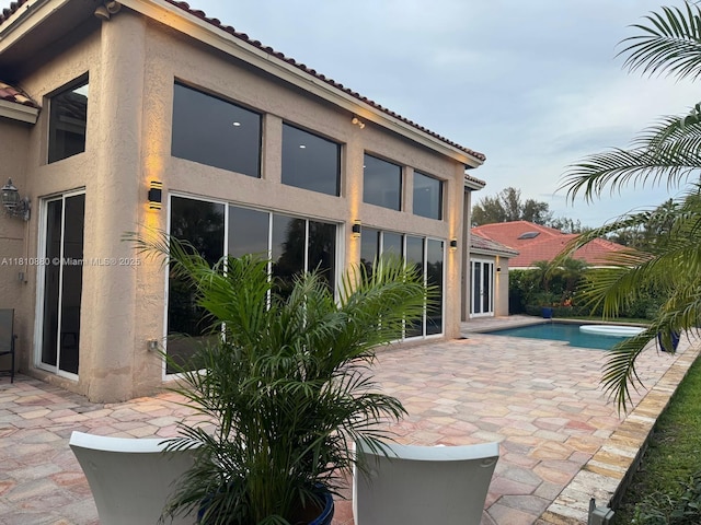 10427 Stonebridge Blvd, Boca Raton, FL 33498 - rear view of property with stucco siding, a patio, an outdoor pool, and a tiled roof