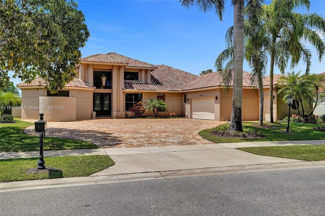 10427 Stonebridge Blvd, Boca Raton, FL 33498 - mediterranean / spanish-style home featuring stucco siding, a tile roof, french doors, driveway, and an attached garage