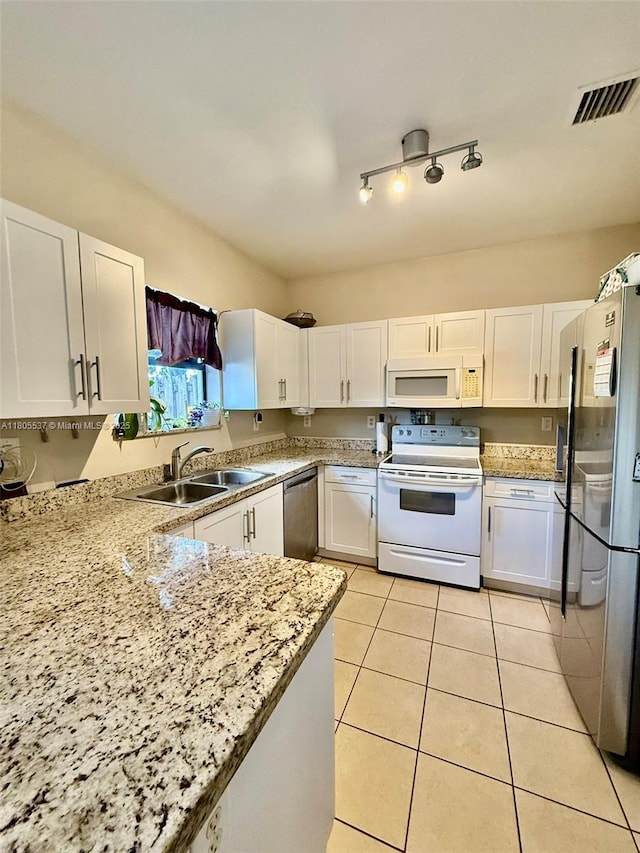 3721 NE 4th Unit 4Th, Homestead, FL 33033 - kitchen with appliances with stainless steel finishes, a sink, white cabinets, light tile patterned floors, and light stone counters