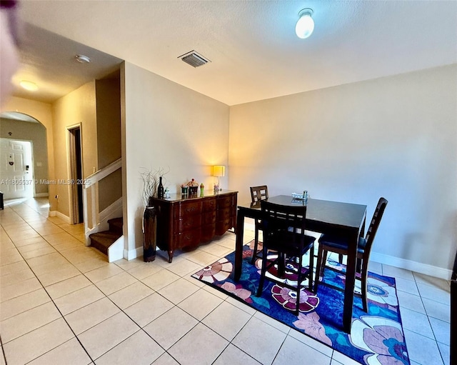 3721 NE 4th Unit 4Th, Homestead, FL 33033 - dining area with arched walkways, light tile patterned flooring, baseboards, and stairs