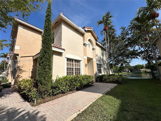 12464 SW 42nd St, Miramar, FL 33027 - view of home's exterior with a yard, stucco siding, a tiled roof, and a water view