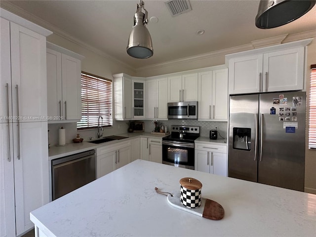 12464 SW 42nd St, Miramar, FL 33027 - kitchen with appliances with stainless steel finishes, a sink, white cabinetry, hanging light fixtures, and decorative backsplash