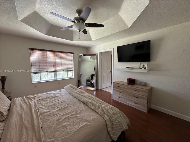 12464 SW 42nd St, Miramar, FL 33027 - bedroom with a textured ceiling, wood finished floors, a raised ceiling, baseboards, and a ceiling fan