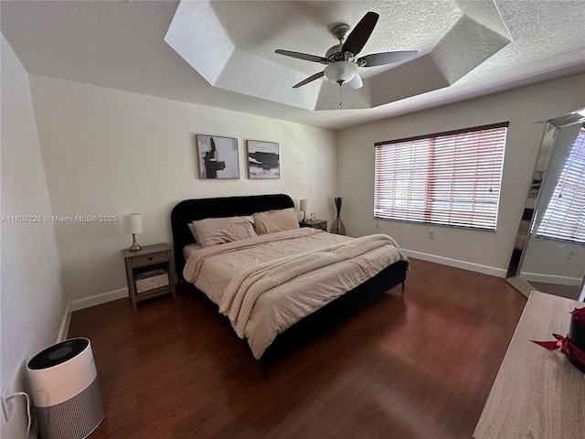 12464 SW 42nd St, Miramar, FL 33027 - bedroom featuring a textured ceiling, dark wood-type flooring, a raised ceiling, baseboards, and ceiling fan